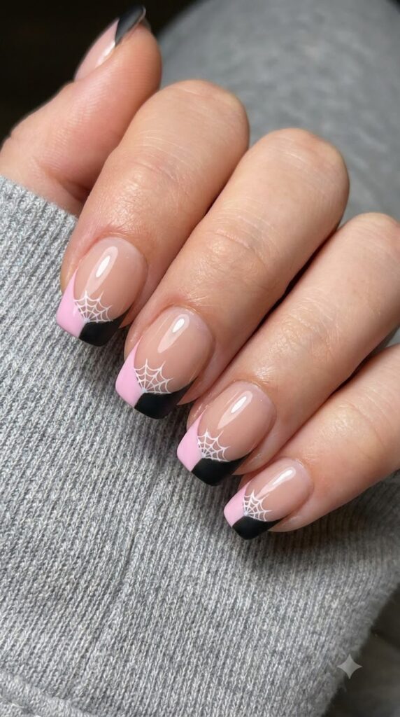 Short squoval nails with half-pink half-black French tips and spiderweb