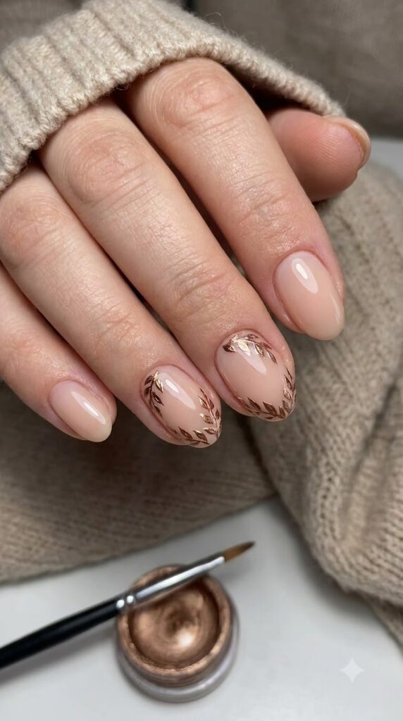 Short oval nude nails with fine hand-painted bronze chrome leaf outlines