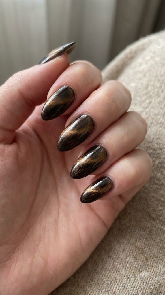 Almond espresso magnetic cat-eye nails with golden-brown shimmer swirls
