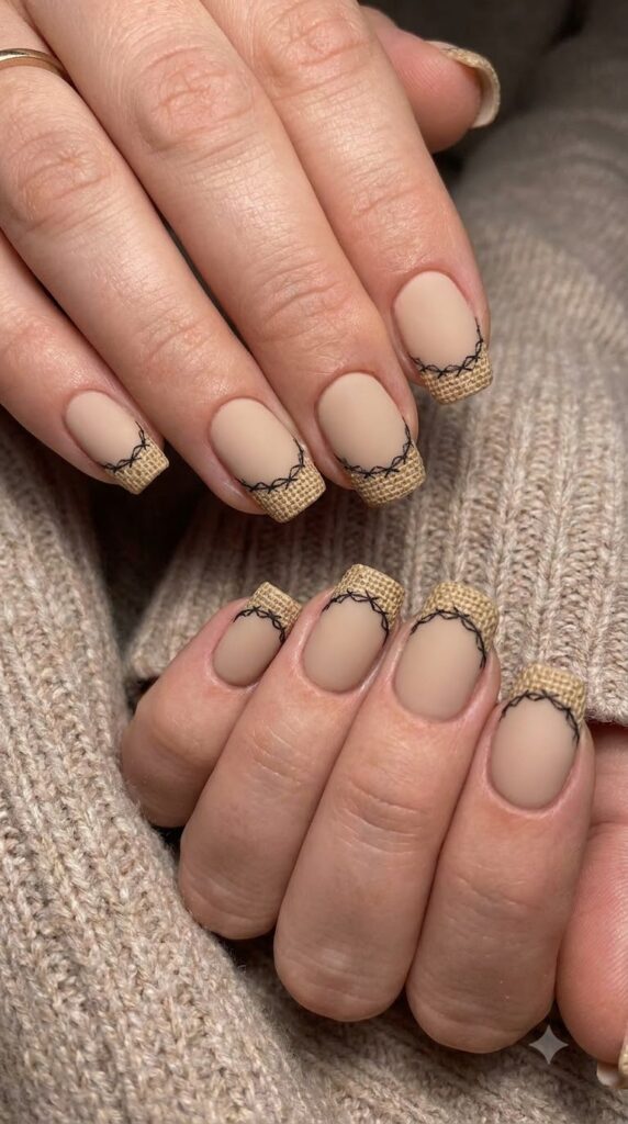 Short squoval beige nude nails with burlap tan French tips and black stitches