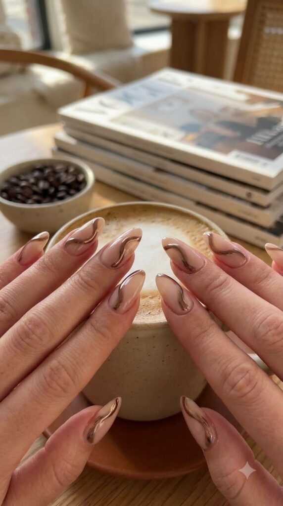 Almond milky nude nails decorated with flowing mocha brown chrome swirls