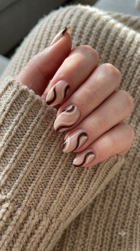 Short almond nude nails with flowing espresso brown and cream swirls