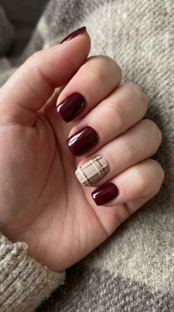 Short square burgundy red nails with a beige cream brown plaid grid accent