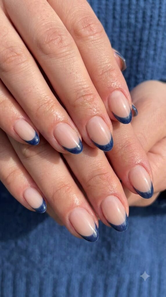 Short almond nude nails with crisp dark denim blue French tips