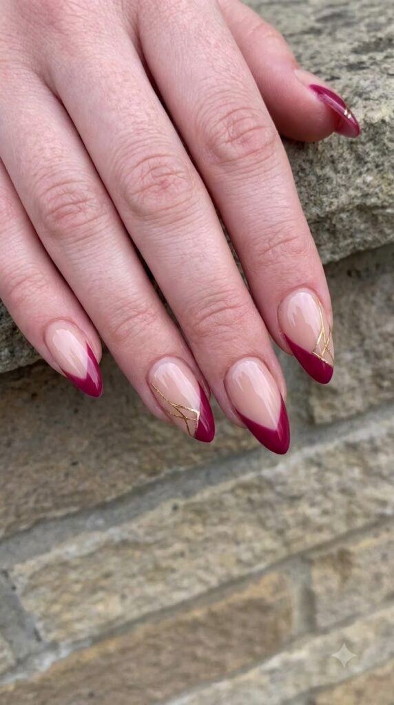 Almond nude nails with deep berry red side-swept French tips