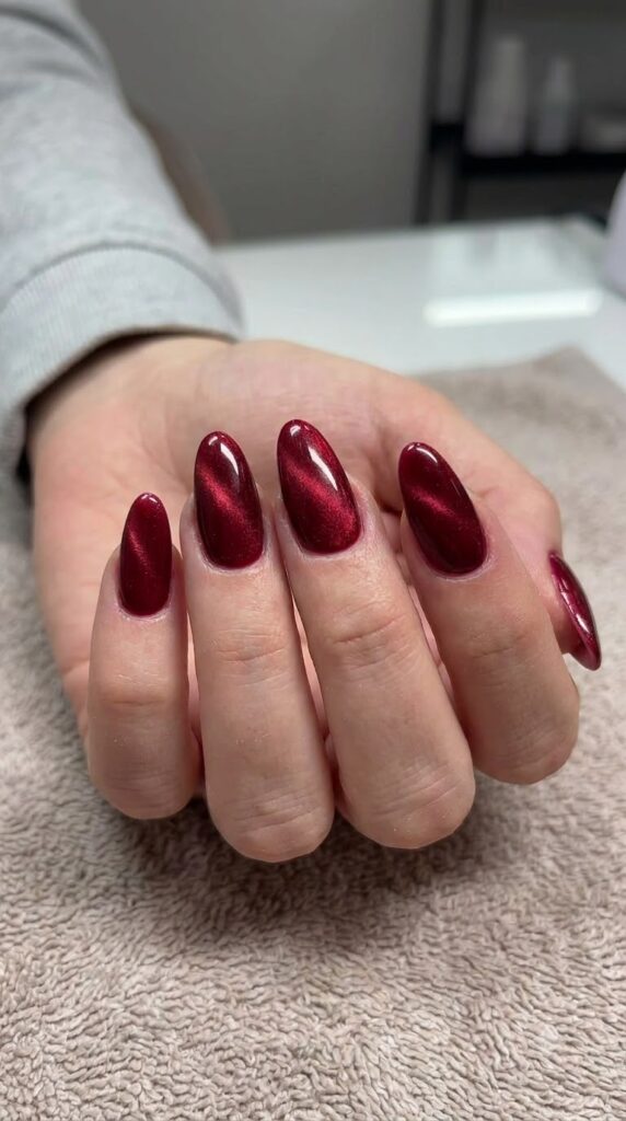 Medium almond nails with deep crimson red magnetic cat-eye velvet polish