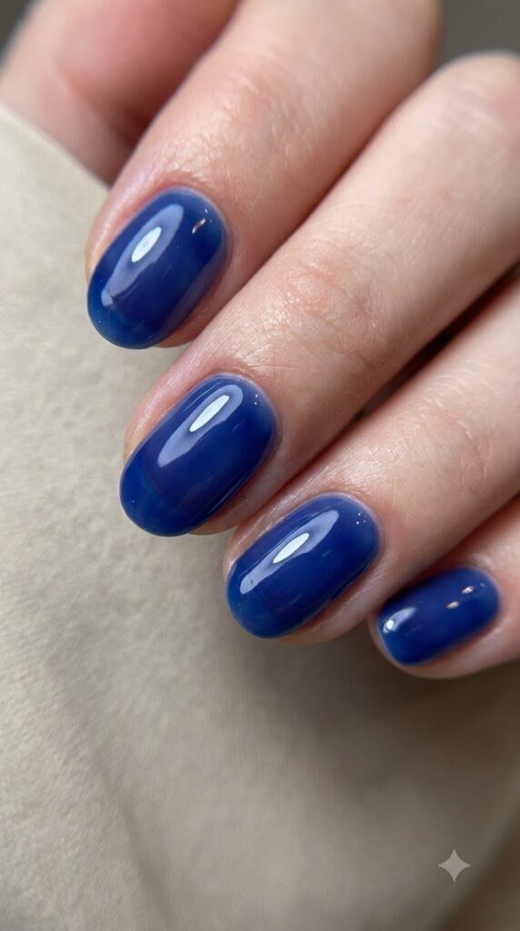 Short oval translucent deep ocean blue jelly nails with glass-like shine