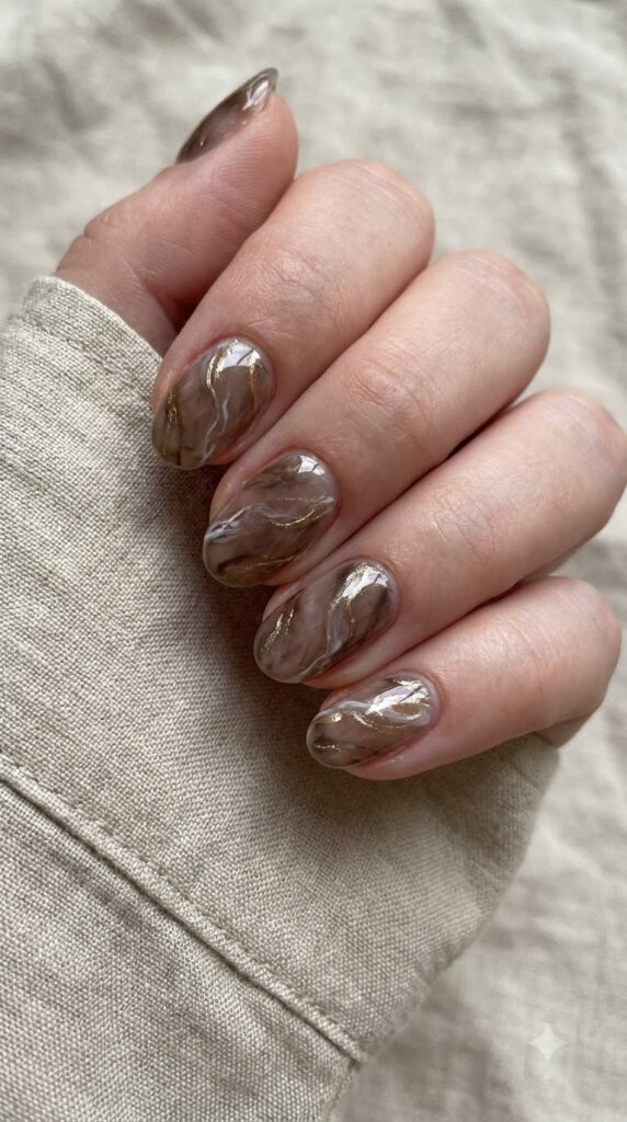 Short oval smoky brown marble nails with soft white and gold veins