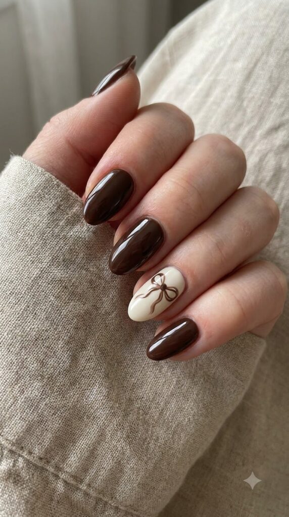 Short almond dark chocolate gel nails with cream ribbon bow line art