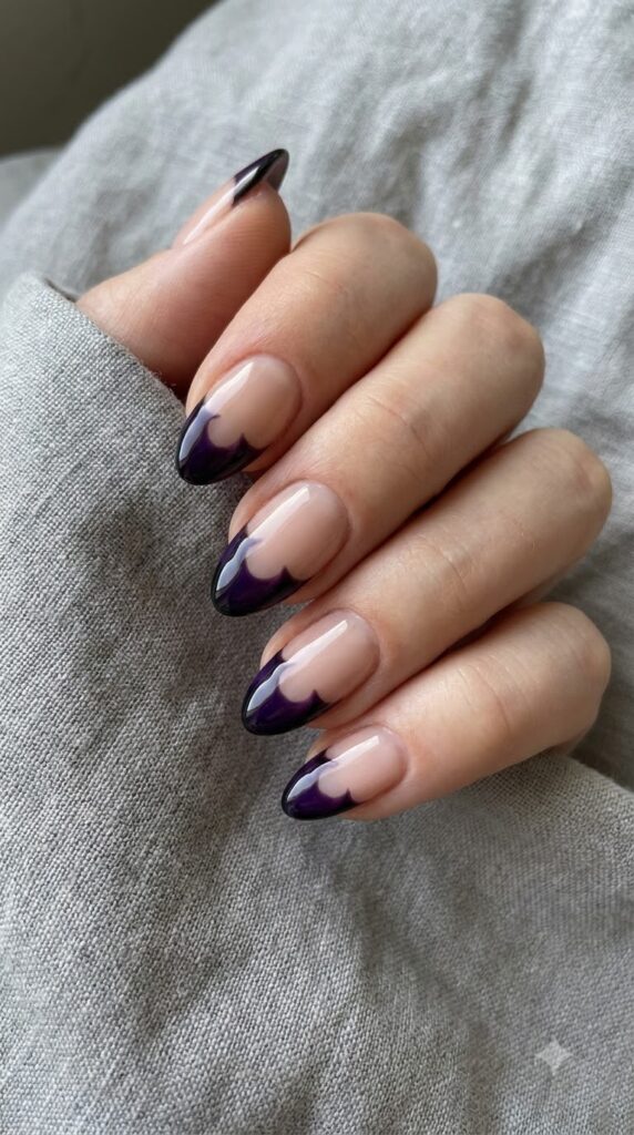 Short almond nude nails with violet French tips shaped like black bat wings