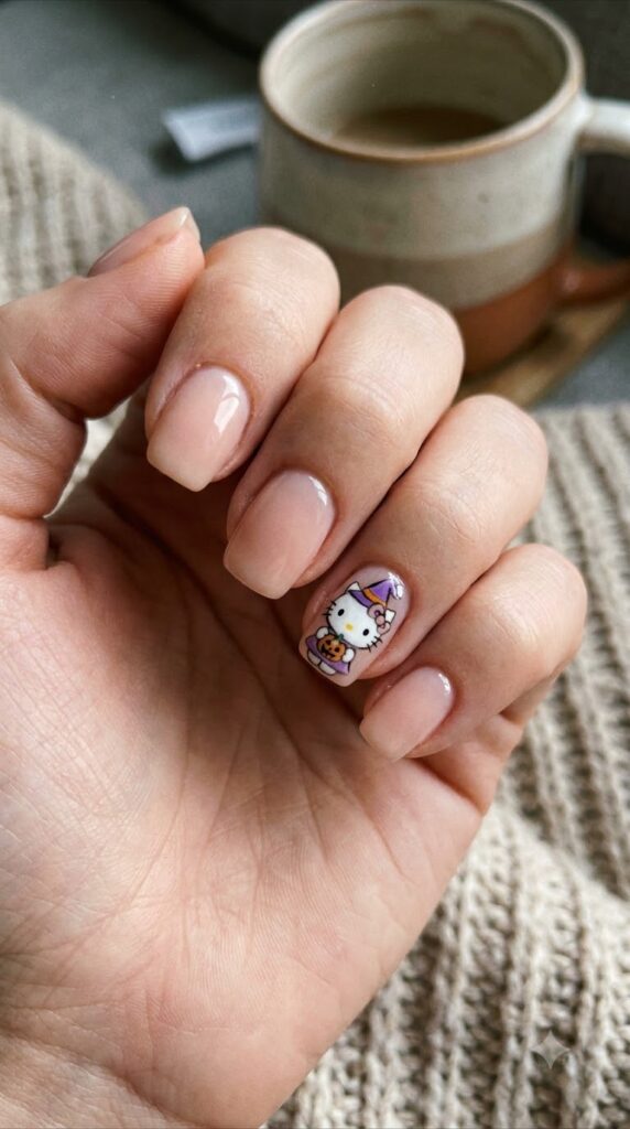 Short squoval blush nails with Hello Kitty wearing a purple witch hat