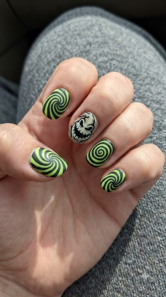 Short round nails with black and lime green hypnotic spiral line art