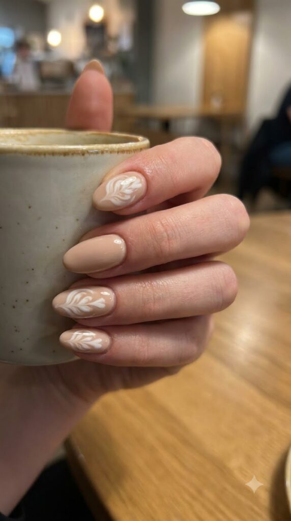 Short almond beige nails with white latte foam swirl art