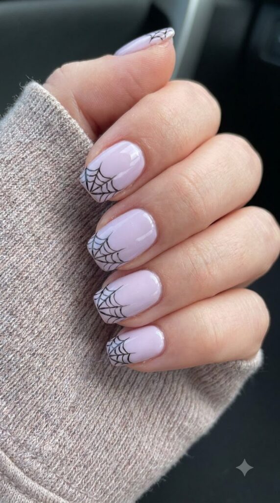 Short squoval nails with pastel lilac base and fine black spiderweb tips