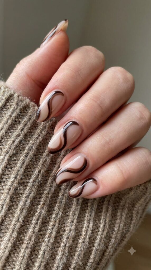 Almond nails with milky nude base and abstract espresso brown swirl lines