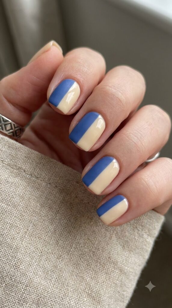 Short square nails split vertically with muted cobalt blue and warm cream