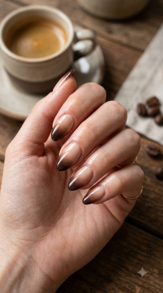 Short almond nails with nude base fading into dark chocolate brown tips