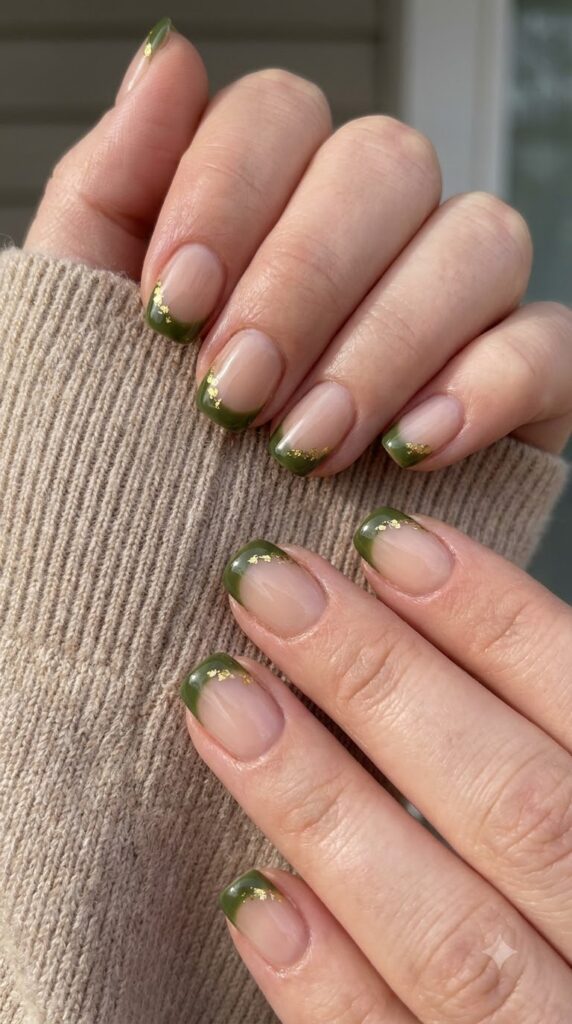 Short squoval nude nails with olive green French tips and gold foil flecks