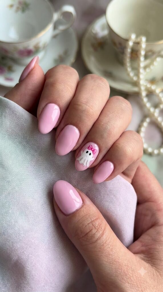 Short almond pastel pink nails with tiny white ghost wearing a pink bow