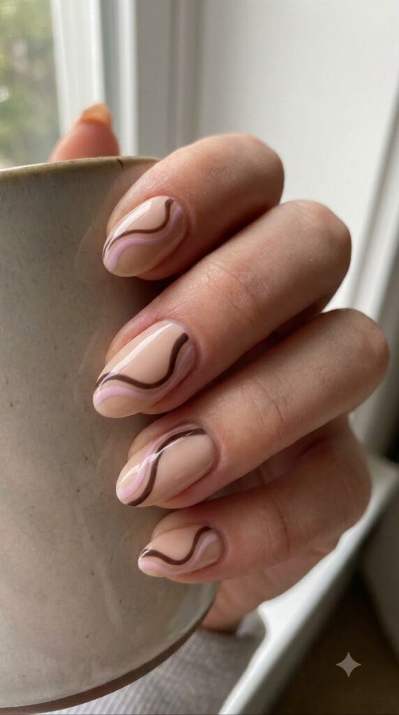 Short almond nude nails with pastel pink and dark chocolate brown swirls