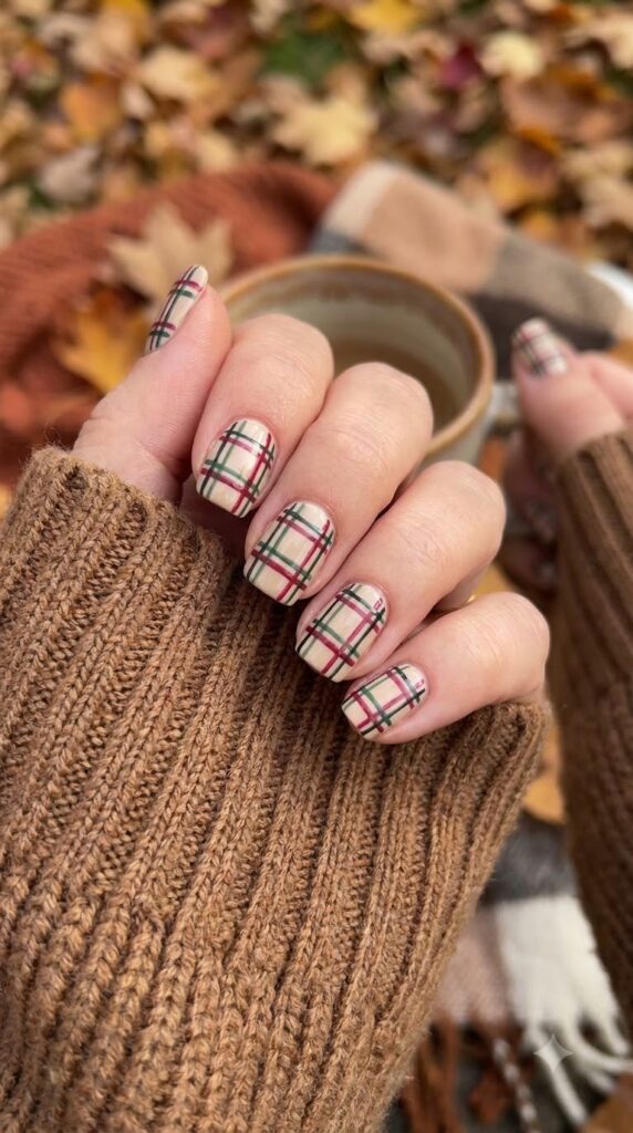 Short square beige nails with red, green, and black plaid pattern