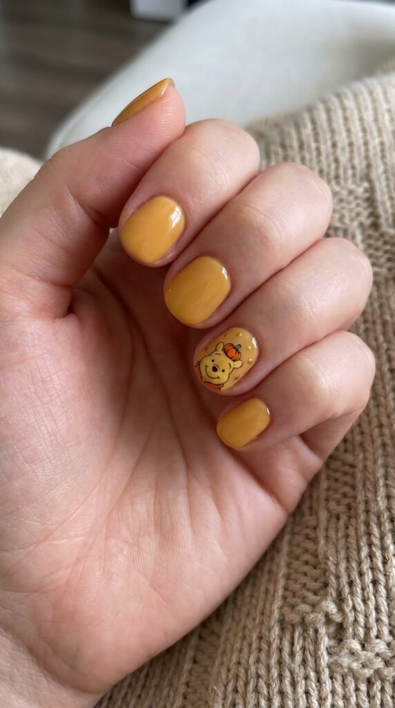 Short round honey yellow nails with Winnie the Pooh in a pumpkin hat