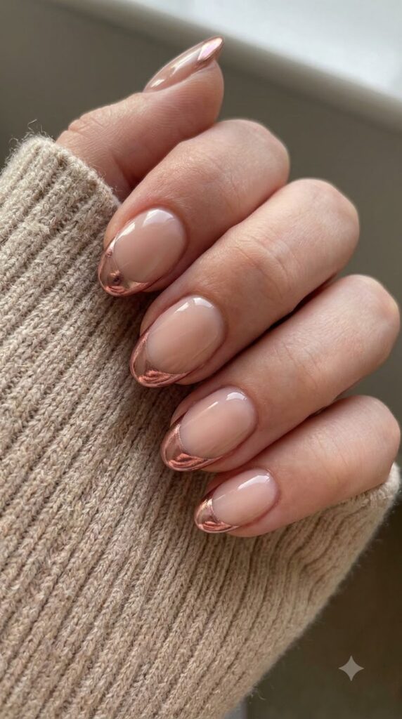 Short almond nude nails with crisp metallic rose gold chrome French tips