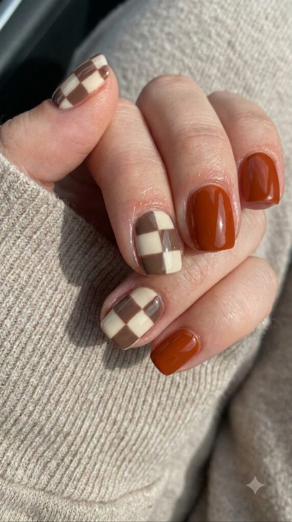 Short square rust orange gel nails with mocha brown and cream checkerboard art