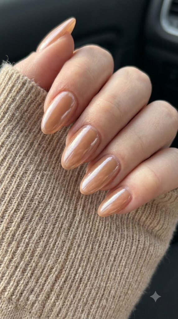 Medium almond sheer caramel nude gel nails with glazed chrome powder finish
