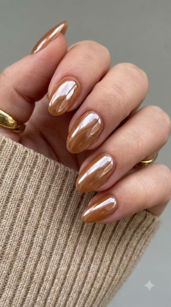 Short almond sheer caramel nails with high-shine glazed chrome finish