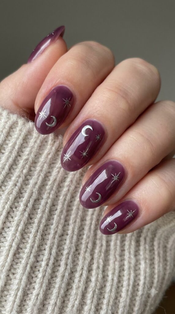 Oval sheer dark plum jelly nails with metallic silver crescent moon decals
