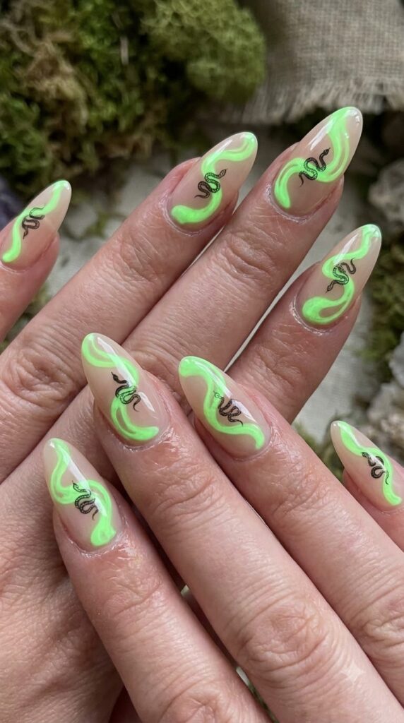 Long almond nude nails with neon green potion swirls and black snake outlines