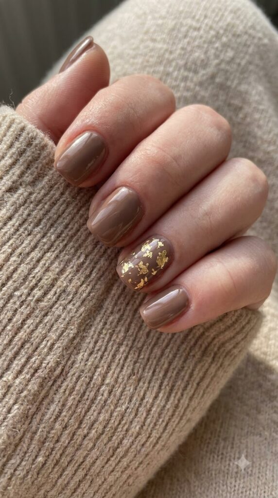 Short squoval taupe brown nails with scattered gold leaf foil flecks