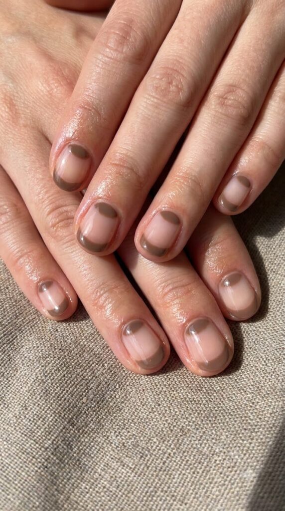 Short round clear nails with warm taupe brown cuticle half-moons