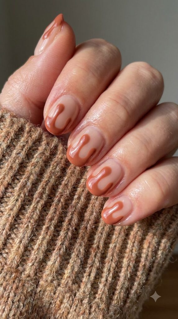 Short round nude gel nails with glossy terracotta clay orange drip art tips