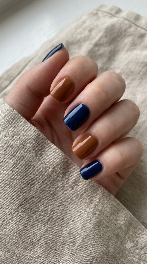 Short square nails alternating solid deep navy blue and warm cognac brown