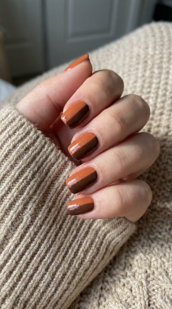 Short square nails split diagonally with terracotta orange and deep brown