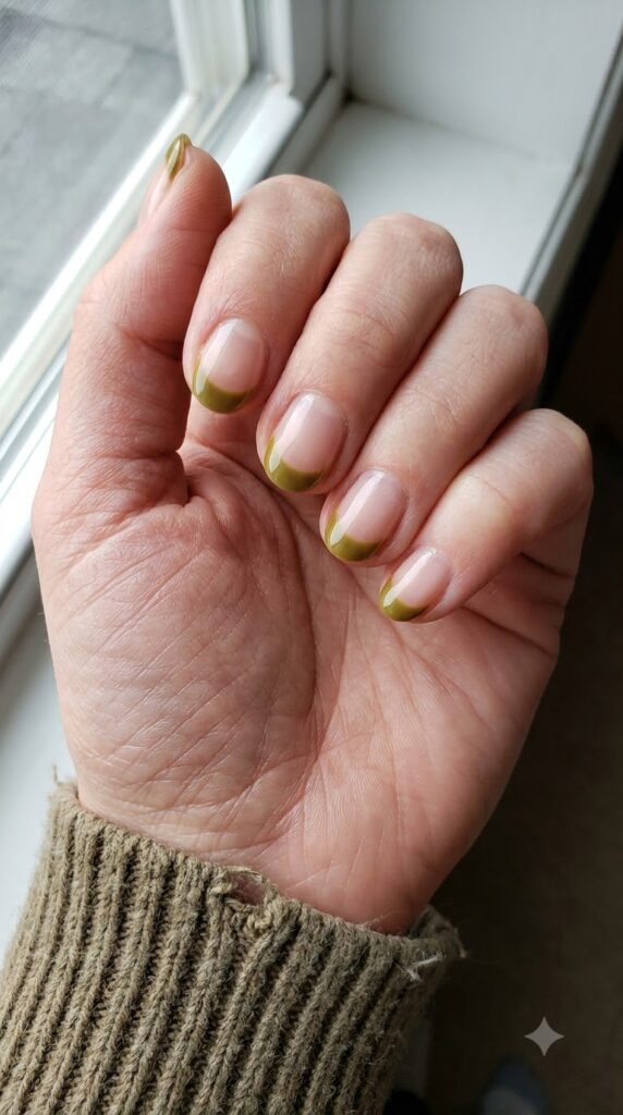 Short round clear nails with warm olive green cuticle half-moons