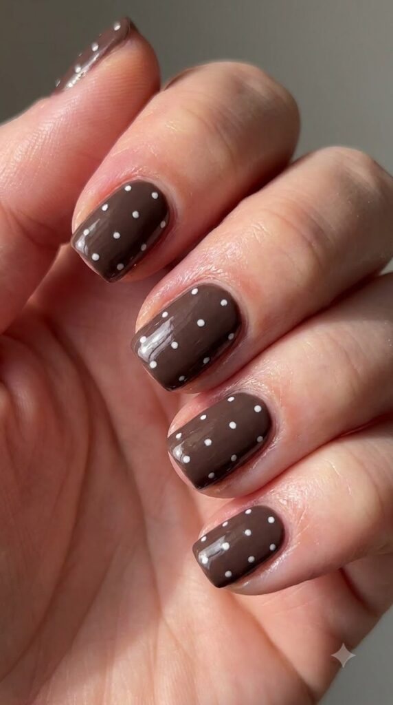 Short squoval mocha brown nails with tiny hand-painted white polka dots
