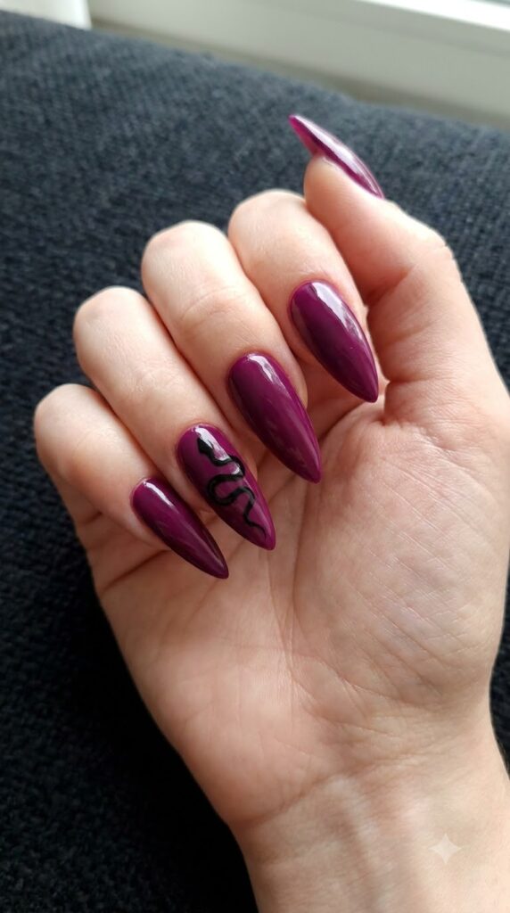 Stiletto dark magenta purple nails with coiled black snake silhouette art