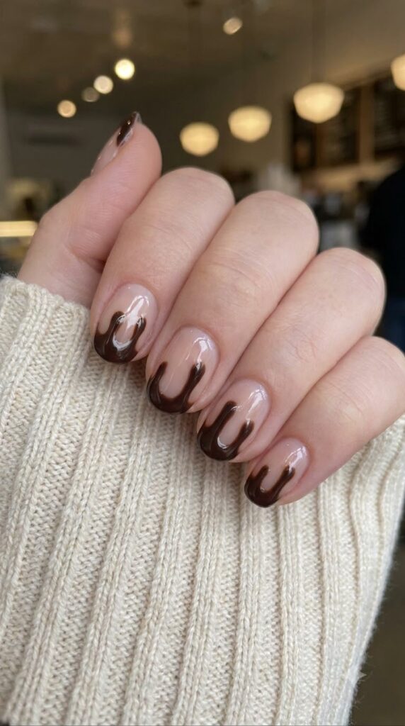 Short round nude nails with glossy dark chocolate truffle drip art tips