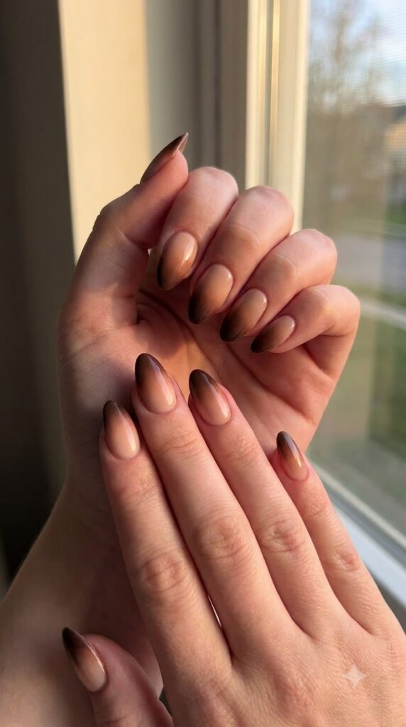 Almond nails with nude base fading smoothly into deep espresso brown tips