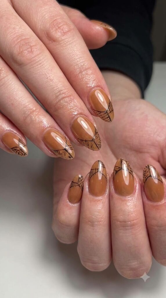 Almond glazed caramel chrome nails with fine black patchwork outline tips