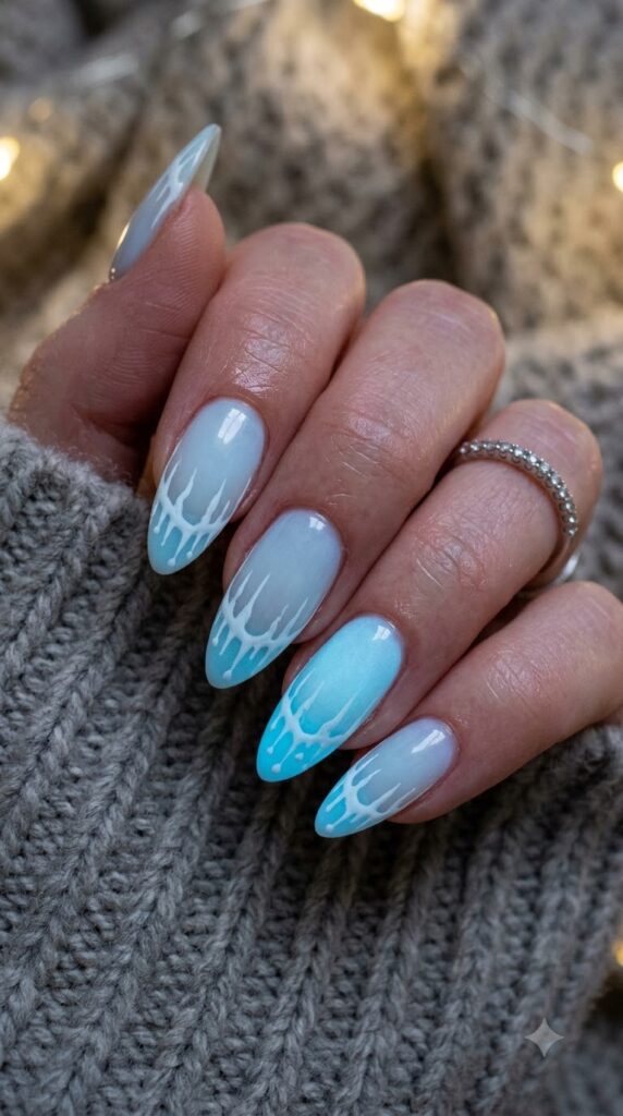Almond pale ice blue glow nails with crisp white icicle drip lines along tips