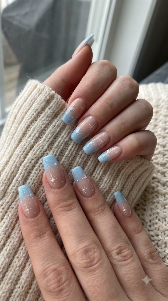Medium coffin nails with nude base fading into icy sky blue starburst glitter tips