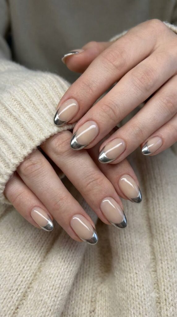 Short almond nude nails with crisp metallic silver chrome French tips